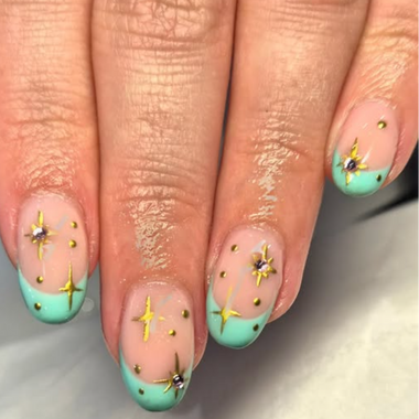 Nails with turquoise polish and gold star designs on a neutral background