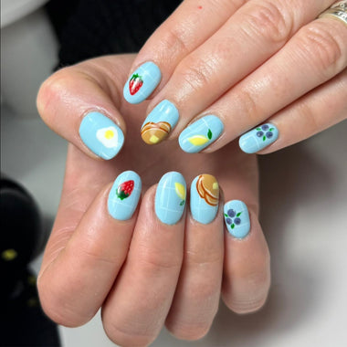 Nails with colorful designs held by a person
