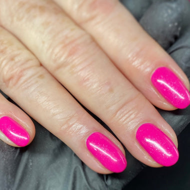 Close-up of a hand with bright pink nail polish on a dark background