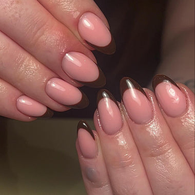Close-up of two hands with pink and brown nail polish on a neutral background