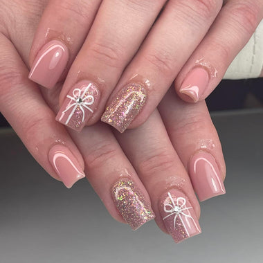Nails with pink and glitter design on a neutral background