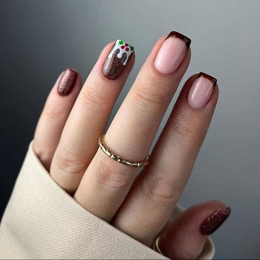 Close-up of a hand with maroon and pink nail polish on a gray background