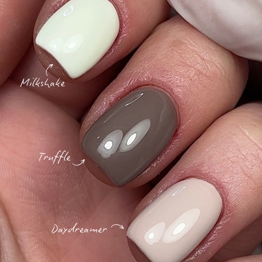 Close-up of a hand with nails painted in 'Milkshake', 'Truffle', and 'Daydreamer' colors.