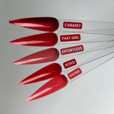 Red nail polish bottles with labels on a gray background