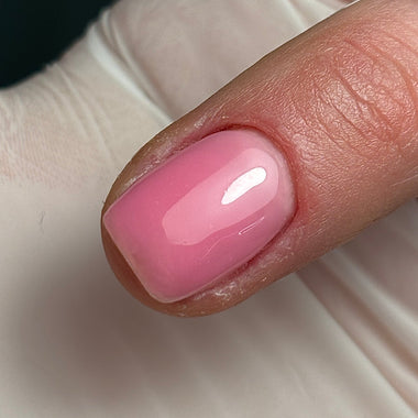 Close-up of a pink nail on a neutral background