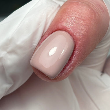 Close-up of a hand with a beige nail polish