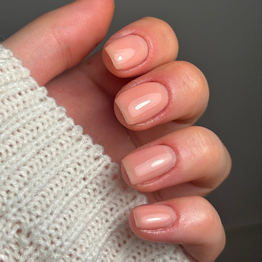 Close-up of a hand with neatly manicured nails wearing a textured white sleeve.
