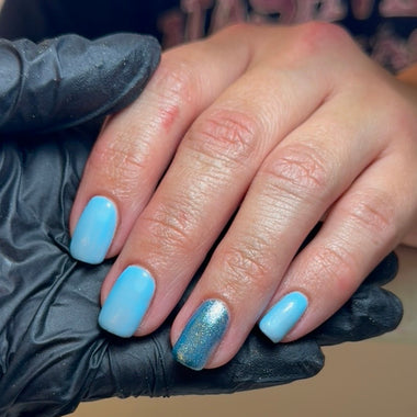 Hand with blue nail polish held by a person wearing black gloves.