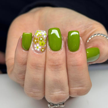 Hand with green nail polish on a neutral background