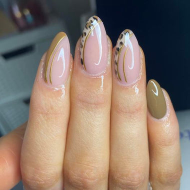 Nail art with gold and black patterns on a neutral background