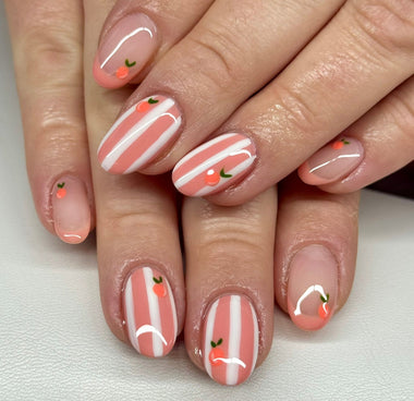 Nails with candy cane design and cherry decorations on a white background