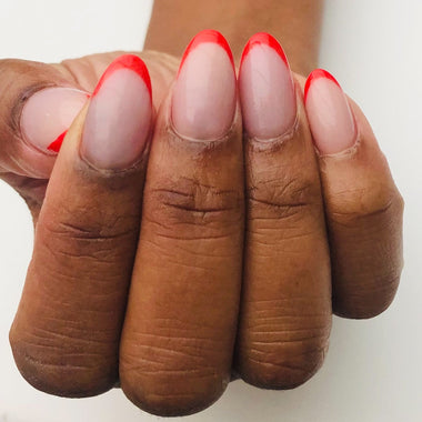 Close-up of a hand with red nail polish on a white background