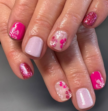 Close-up of a hand with pink and white nail polish on a gray background