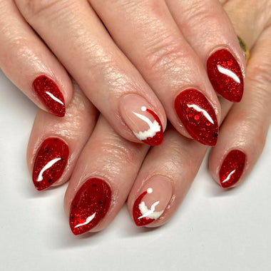 Close-up of hands with red glittery nail polish on a white background