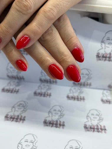Close-up of hands with red nail polish on a patterned background