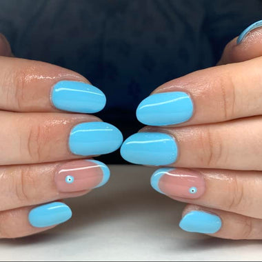 Close-up of hands with light blue nail polish on a neutral background