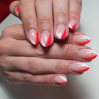 Close-up of hands with red and white nail polish on a neutral background