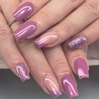 Hand with pink and purple gradient nails on a neutral background