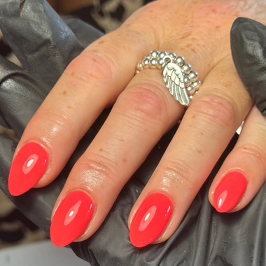 Hand with red nail polish wearing a silver ring on a dark background