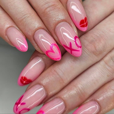 Close-up of hands with pink and red nail art on a neutral background
