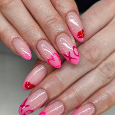 Close-up of hands with pink and red nail art on a neutral background
