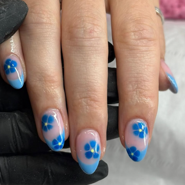 Nails with blue flower design on a neutral background