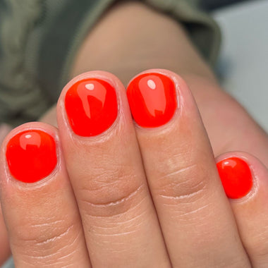 Close-up of toes with bright red nail polish on a blurred background