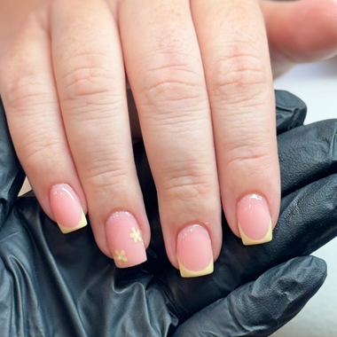 Close-up of hands with pink and yellow nail polish wearing black gloves.