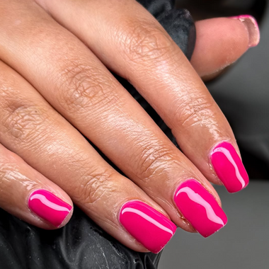 Close-up of a hand with pink nail polish on a dark background
