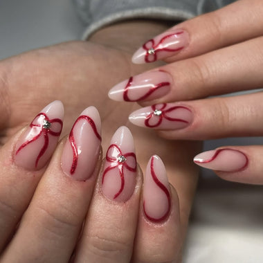 Nails with red and white design on a neutral background