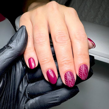 Hand with deep pink nail polish holding a black glove HGP Burgundy