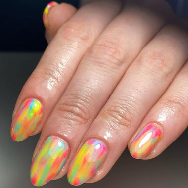 Close-up of a hand with multicolored nail art on a dark background