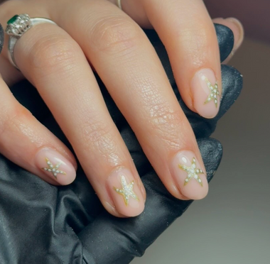 Close-up of a hand with decorative nail art holding a black clutch.