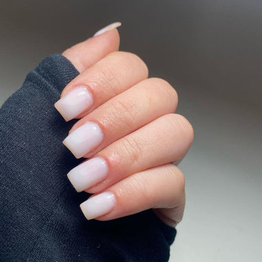 Hand with white nail polish on a neutral background