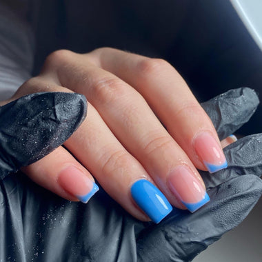 Hand with blue nail polish wearing a black glove