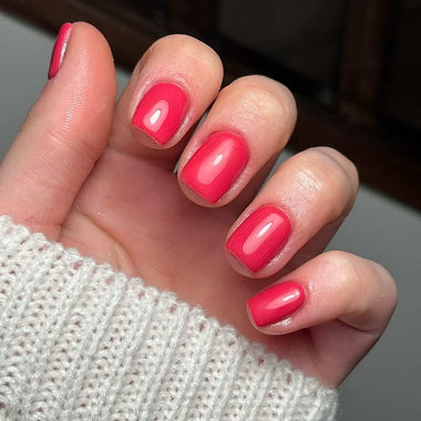 Hand with red nail polish on a blurred background