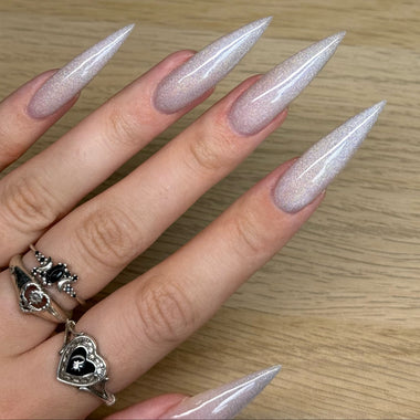 Manicured nails with a glittery finish on a wooden surface
