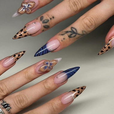 Nails with butterfly and feather designs on a neutral background