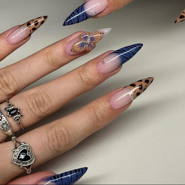 Nails with butterfly and feather designs on a neutral background