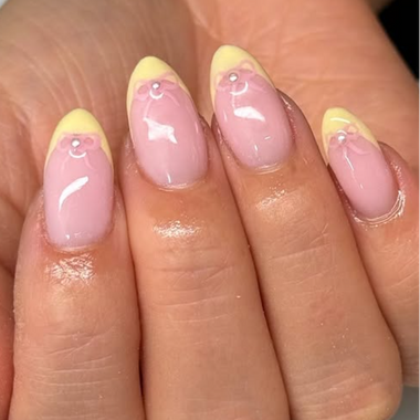 Nails with pink and yellow design on a hand