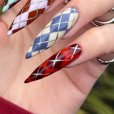 Close-up of a hand with long, colorful nails featuring geometric patterns.