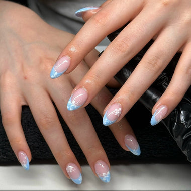 Close-up of hands with blue french manicure nail design on a blurred background