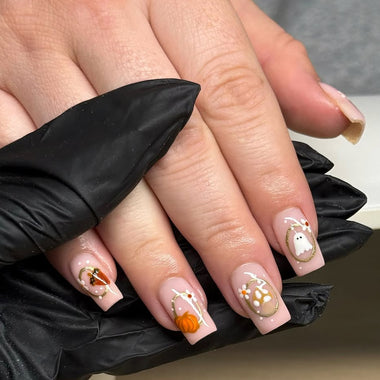Hand with Halloween-themed nail art wearing a black glove.