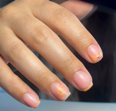 Close-up of a hand with pink nail polish on a blurred background