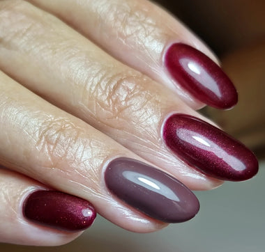 Close-up of a hand with burgundy nail polish on a blurred background