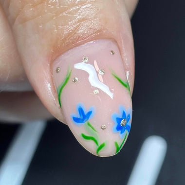 Nail with floral design featuring blue flowers and green leaves on a dark background