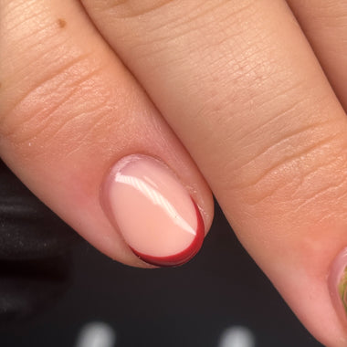 Close-up of a hand with a natural nail and red tip