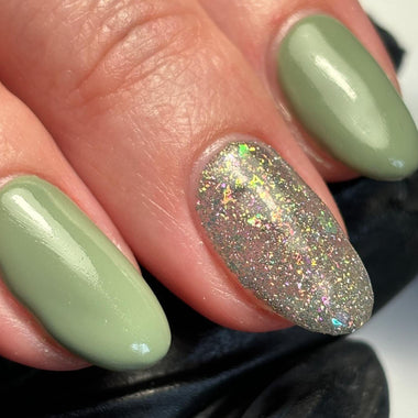 Close-up of a hand with green nail polish on a blurred background