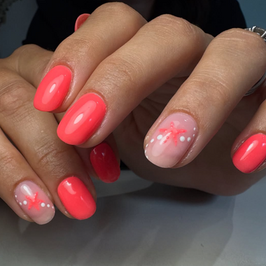 Close-up of hands with halo gel polish coral nail polish and decorative designs on a neutral background