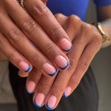 Close-up of hands with blue nail polish on a blurred background
